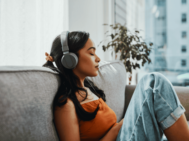 woman on couch listen to music