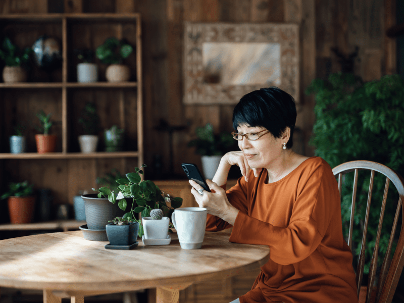 woman at table looking to see if her child has called her to wish her happy birthday