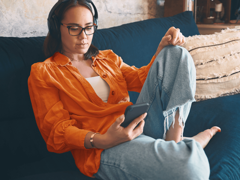 Woman on couch searching Best Self Care Apps of 2021