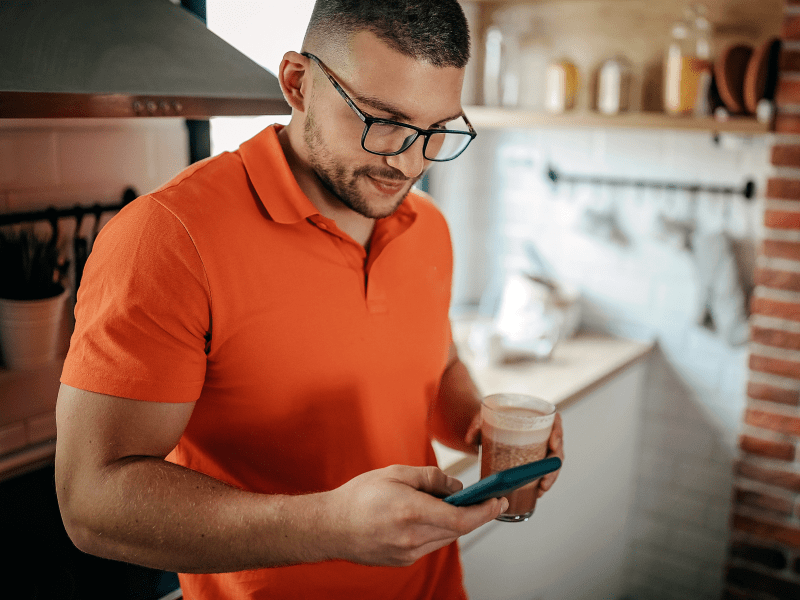 man in ornage shirt changing his payment method while having coffee